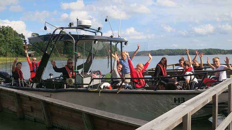 Sveriges Funktionshindrades Frilufts & Fiskeförening - bild på båten där alla ombord vinkar